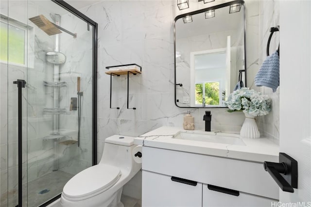 bathroom with vanity, toilet, a shower with door, and tile walls