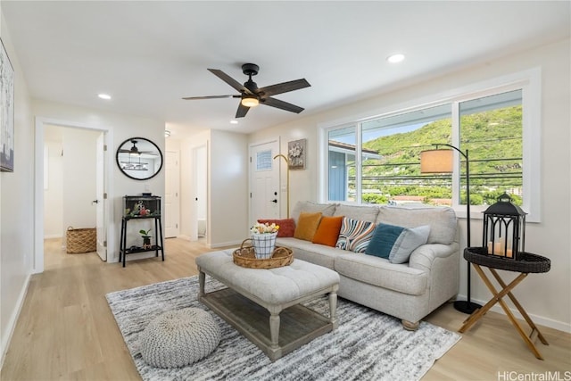 living room with ceiling fan and light hardwood / wood-style flooring