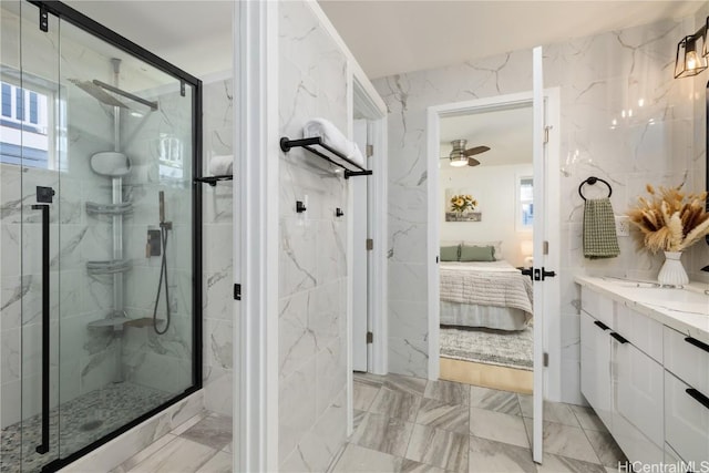 bathroom with ceiling fan, vanity, a shower with shower door, and tile walls