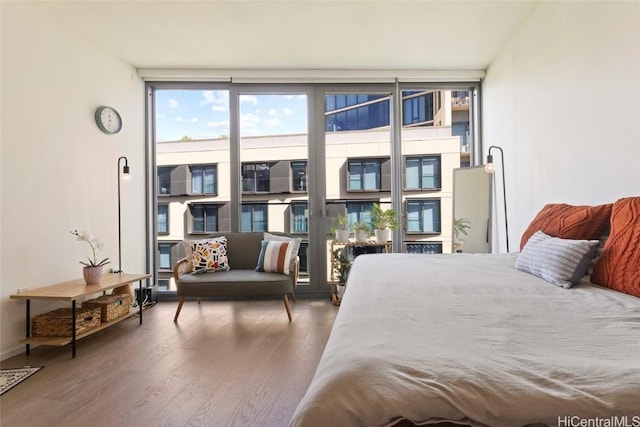 bedroom featuring dark wood-type flooring and a wall of windows