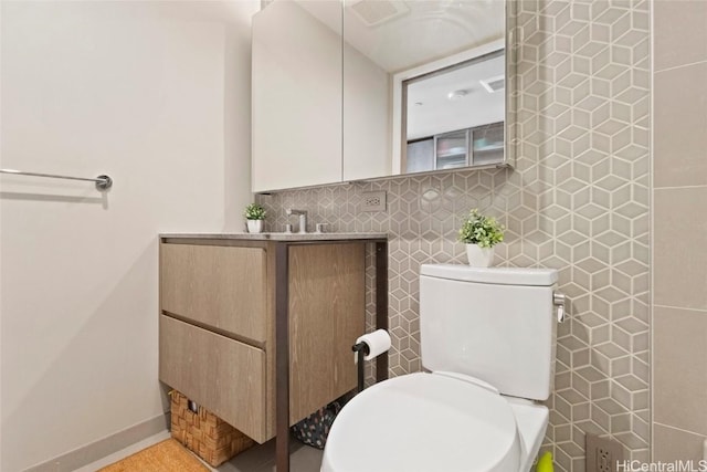 bathroom with tile walls, vanity, decorative backsplash, and toilet