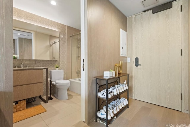 full bathroom featuring decorative backsplash, tiled shower / bath, vanity, and toilet