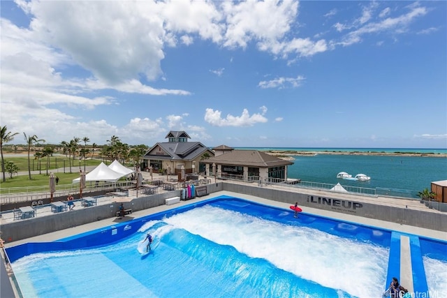 pool with a gazebo, fence, a water view, and a patio area