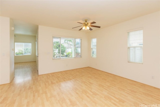 spare room with a healthy amount of sunlight, a ceiling fan, and light wood-style floors