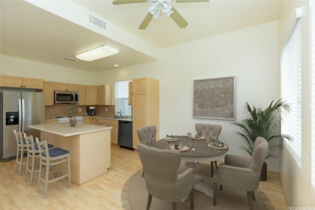 91-1137 Kai Kukuma St, Ewa Beach, HI 96706 - kitchen featuring appliances with stainless steel finishes, light brown cabinetry, decorative backsplash, light wood-style floors, and a center island