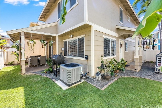 back of property with a patio area, a lawn, fence, and central air condition unit