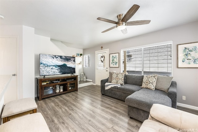 living area featuring a ceiling fan, baseboards, and wood finished floors