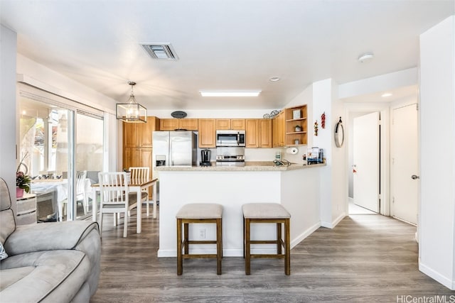 kitchen featuring visible vents, wood finished floors, stainless steel appliances, light countertops, and open shelves