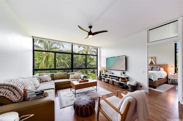 living room with plenty of natural light, ceiling fan, floor to ceiling windows, and wood finished floors