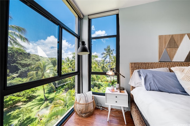 bedroom featuring expansive windows and wood finished floors