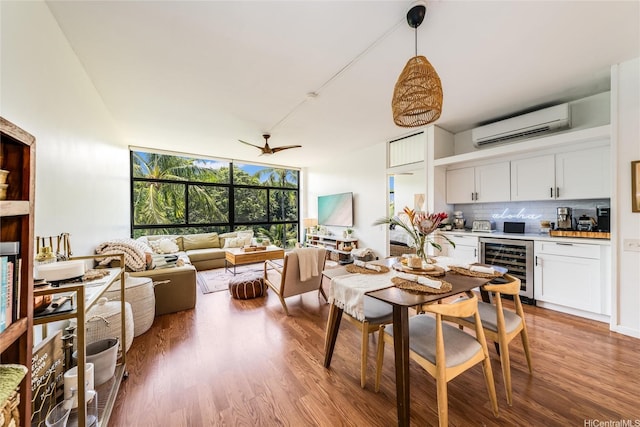 dining space with indoor bar, light wood finished floors, ceiling fan, a wall unit AC, and beverage cooler