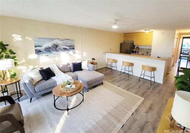 living room with ceiling fan and light hardwood / wood-style floors