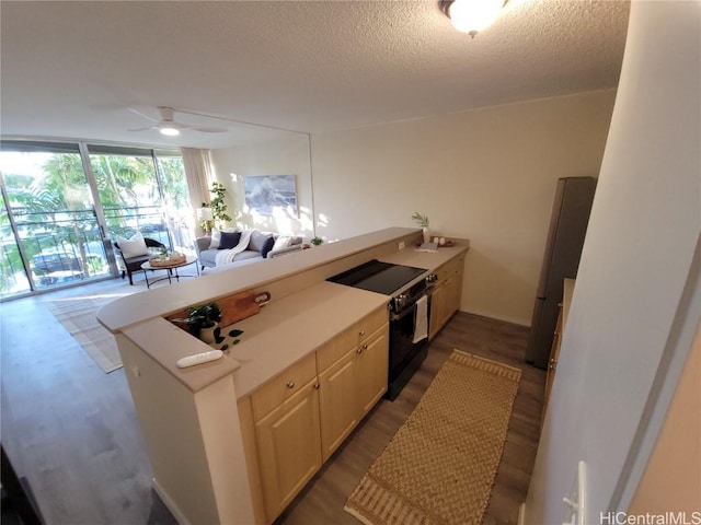 kitchen with electric range oven, stainless steel fridge, floor to ceiling windows, dark wood-type flooring, and a textured ceiling