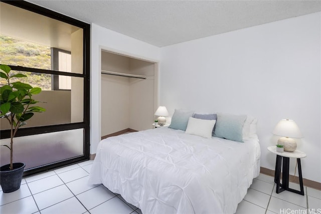 tiled bedroom with a closet and a textured ceiling