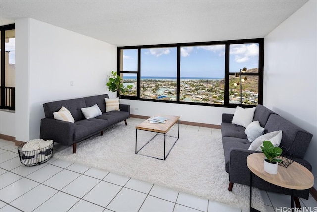 living room featuring a water view and light tile patterned flooring