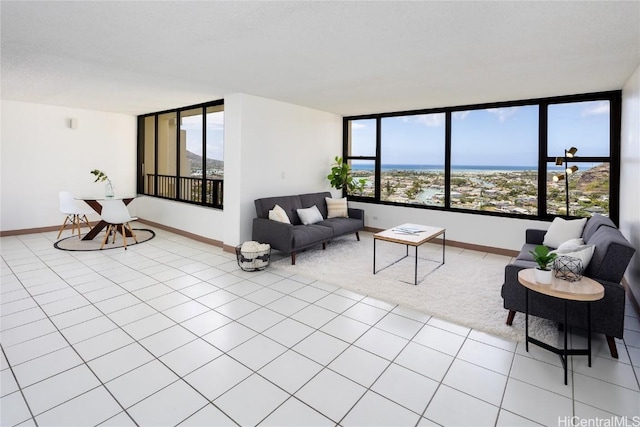 living room with light tile patterned floors, plenty of natural light, and a water view