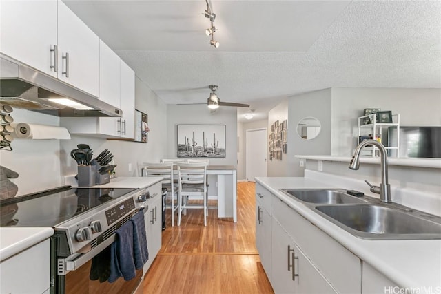 kitchen with light hardwood / wood-style flooring, sink, stainless steel electric range, and white cabinets