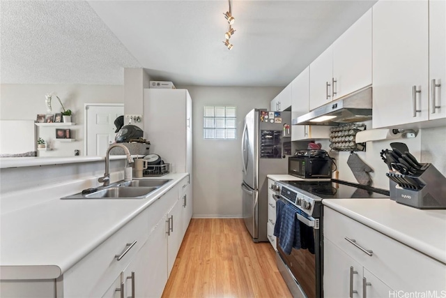 kitchen featuring stainless steel appliances, white cabinetry, sink, and light hardwood / wood-style floors