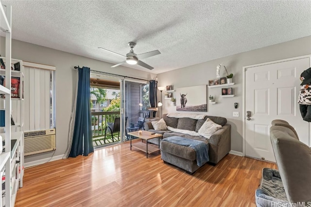 living room featuring wood-type flooring, cooling unit, a textured ceiling, and ceiling fan