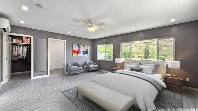 bedroom featuring a wall mounted air conditioner, wood-type flooring, and ceiling fan