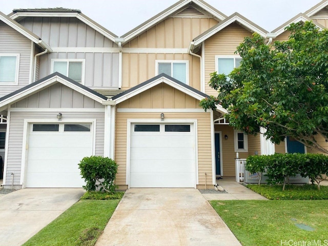 view of property featuring board and batten siding, driveway, and a garage