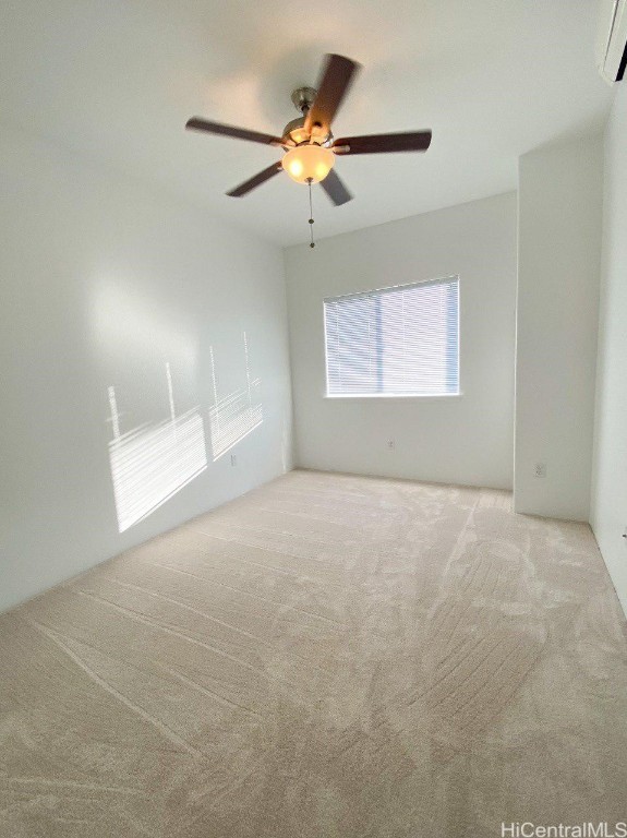 carpeted empty room with ceiling fan and a wall mounted AC