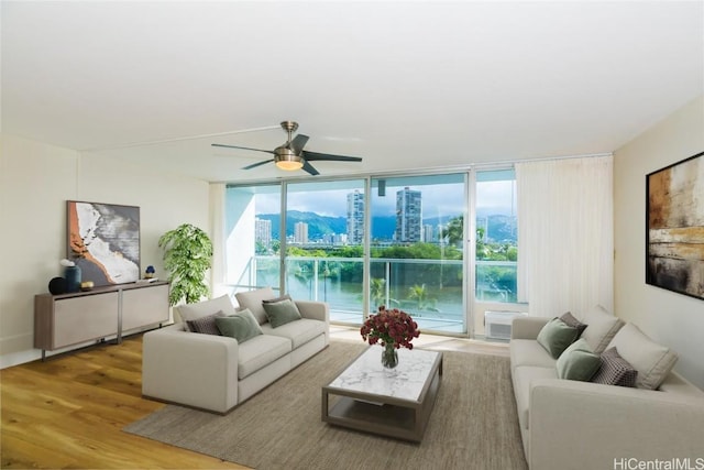 living room with a wealth of natural light, wood-type flooring, and expansive windows