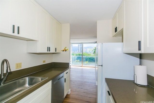 2233 Ala Wai Blvd Unit 5B, Honolulu, HI 96815 - kitchen with dark countertops, wood finished floors, stainless steel dishwasher, a sink, and white cabinetry