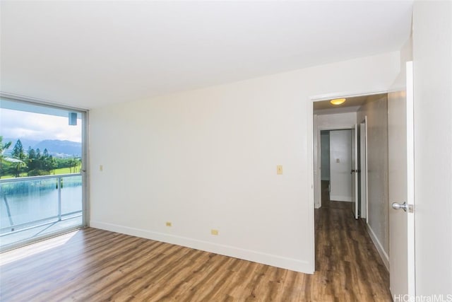 spare room featuring floor to ceiling windows and dark hardwood / wood-style flooring