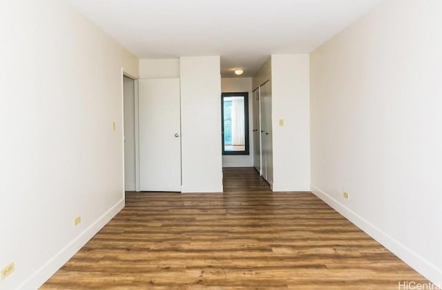 unfurnished bedroom with dark hardwood / wood-style flooring