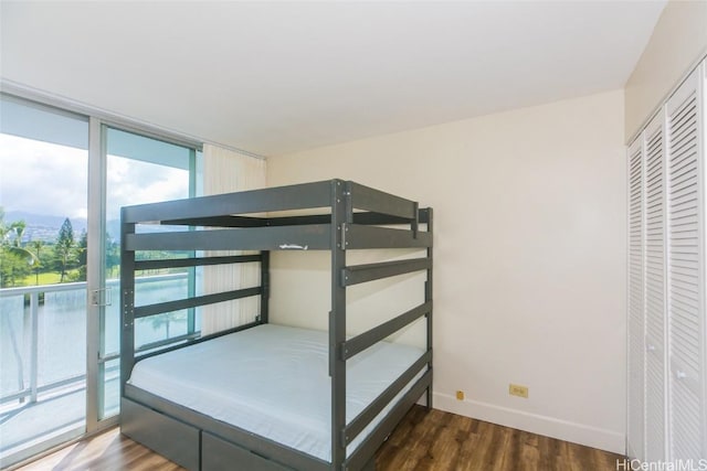 unfurnished bedroom with floor to ceiling windows, dark hardwood / wood-style floors, and access to outside