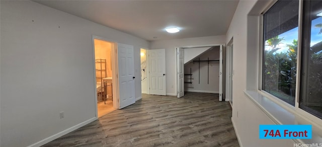 spare room featuring baseboards and dark wood-style flooring