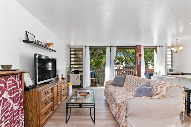 living room featuring floor to ceiling windows, a notable chandelier, and light hardwood / wood-style floors