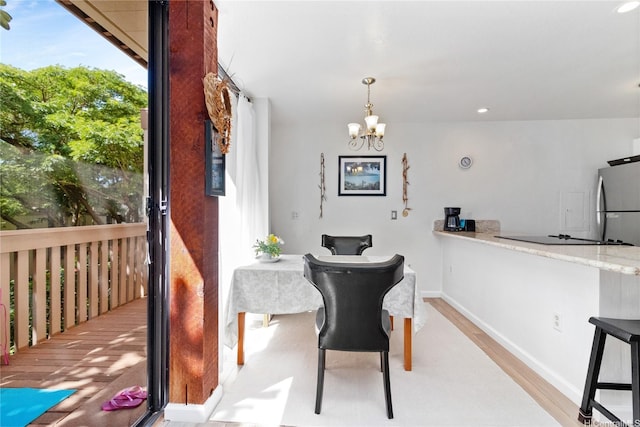 dining area with recessed lighting, baseboards, an inviting chandelier, and wood finished floors