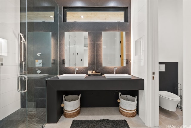 bathroom with a shower stall, tile walls, tasteful backsplash, and a sink