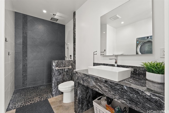 full bath featuring walk in shower, toilet, recessed lighting, a sink, and washer / dryer