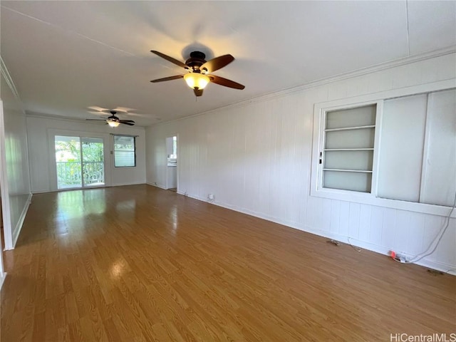 unfurnished room with ceiling fan, hardwood / wood-style flooring, crown molding, and built in features