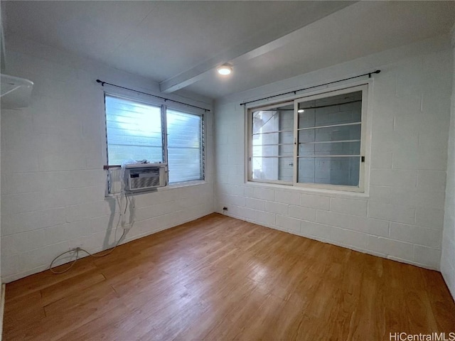 unfurnished room with hardwood / wood-style flooring, cooling unit, and beam ceiling