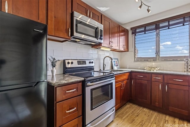 kitchen featuring sink, decorative backsplash, stainless steel appliances, and light hardwood / wood-style floors