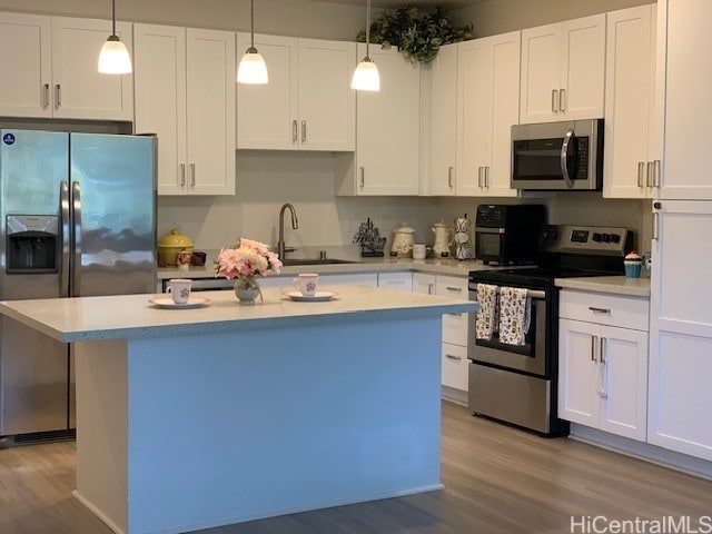 kitchen featuring a kitchen island, white cabinetry, appliances with stainless steel finishes, and sink