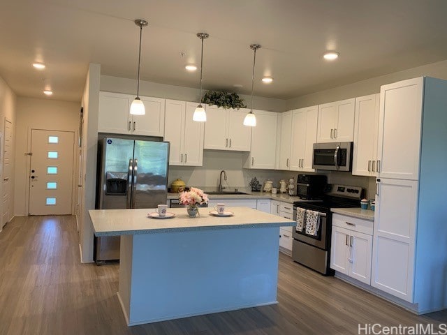 kitchen featuring stainless steel appliances, a kitchen island, sink, and white cabinets