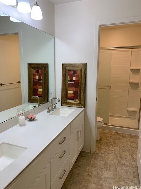 bathroom featuring toilet, vanity, and walk in shower