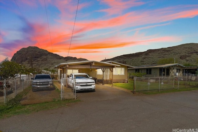 view of front of property featuring driveway, fence, and a mountain view