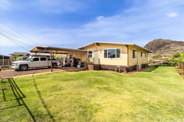 view of front of property with an attached carport, a front yard, and fence