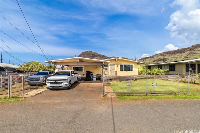 view of front of property featuring a carport, a fenced front yard, a front yard, and driveway