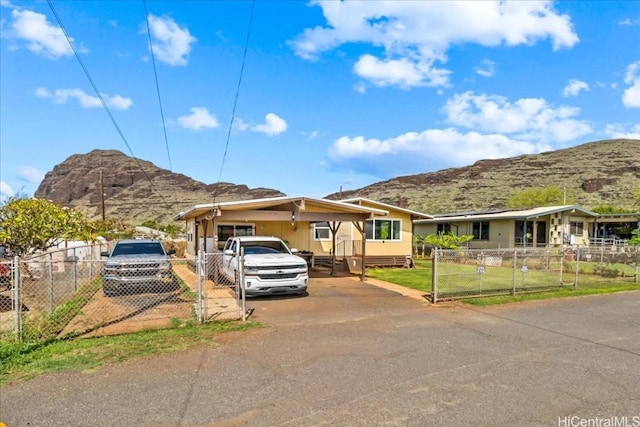 single story home with fence, a mountain view, and a front lawn