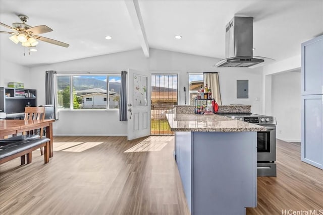 kitchen with lofted ceiling with beams, a kitchen island, light wood-type flooring, stainless steel electric stove, and wall chimney exhaust hood