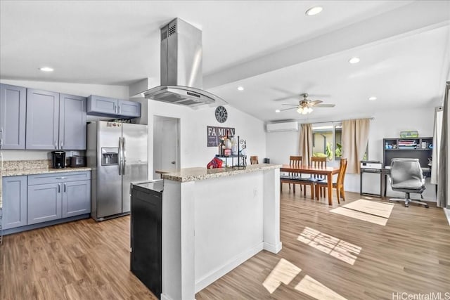 kitchen featuring a wall unit AC, island exhaust hood, a ceiling fan, light wood-type flooring, and stainless steel fridge with ice dispenser