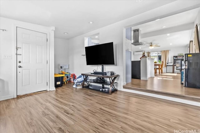 living area featuring light wood-style flooring, a ceiling fan, and recessed lighting