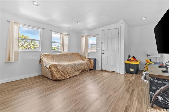 bedroom with recessed lighting, wood finished floors, and baseboards